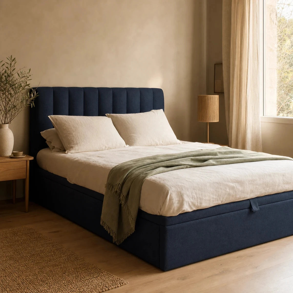 Lit coffre capitonné bleu encre avec linge de lit écru Image