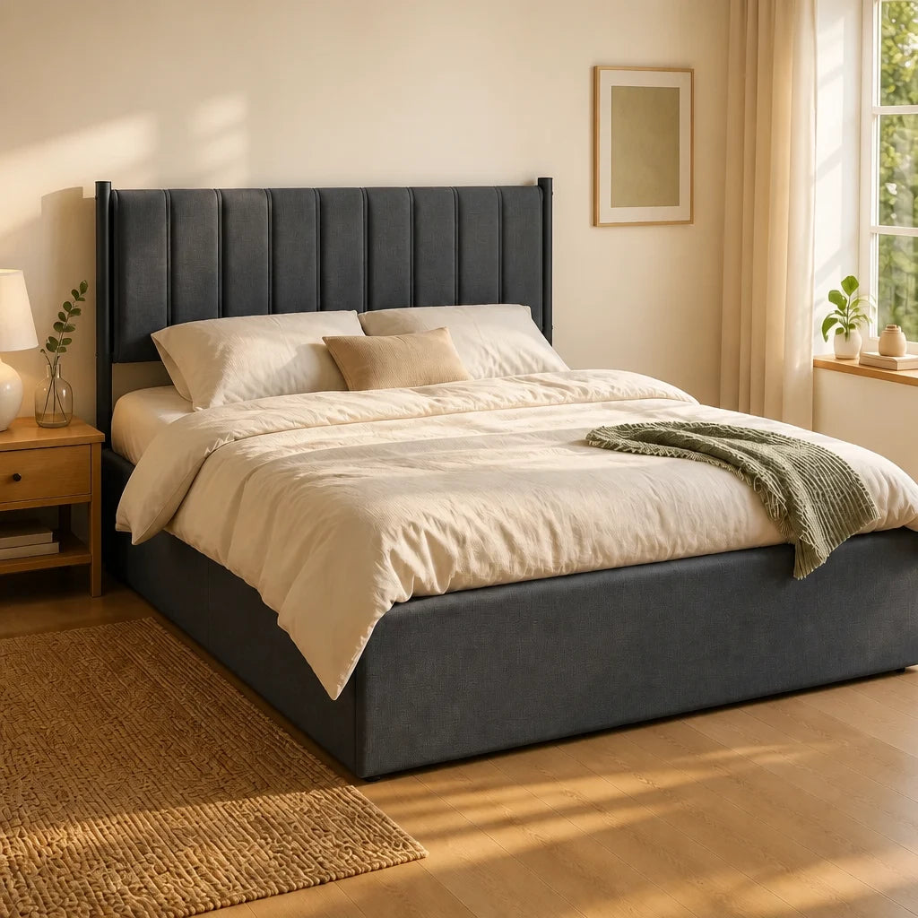 Lit coffre 140x190 en tissu gris charbon, tête de lit cannelée, dans une chambre en lin écru éclairée par la lumière dorée de fin d'après-midi